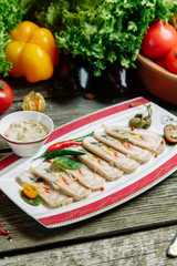 Restaurant dish with vegetable decor on a wooden background. Beef cut-up on a plate with greens.
