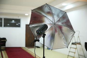 Photographic studio strobe lighting and reflective umbrella . Photo studio Silver Photo Studio...