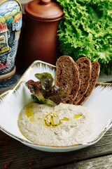 Restaurant dish with vegetable decor on a wooden background. Puree soup with mushrooms and sour cream on a plate.