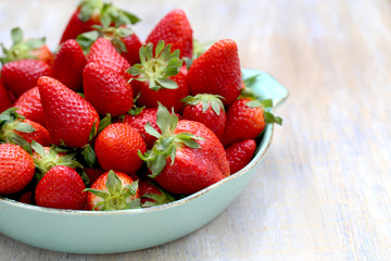 morangos frescos, maduros em um prato na mesa.