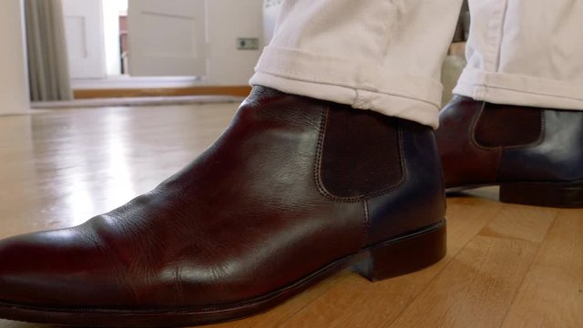 detail of a man's booties dressed in white pants