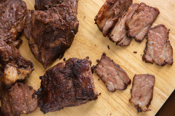 Baked pork cut into pieces on a wooden chopping board