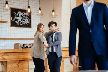 Two coworkers Staring and Gossiping About Their Male Colleague