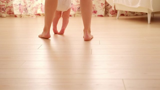 baby first step with mother in children's room