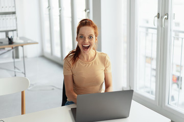 Surprised young businesswoman smiling at camera