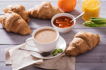 breakfast with fresh croissants and coffee on wooden table