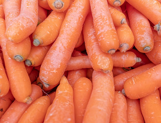 organic carrots top view close up, natural orange background
