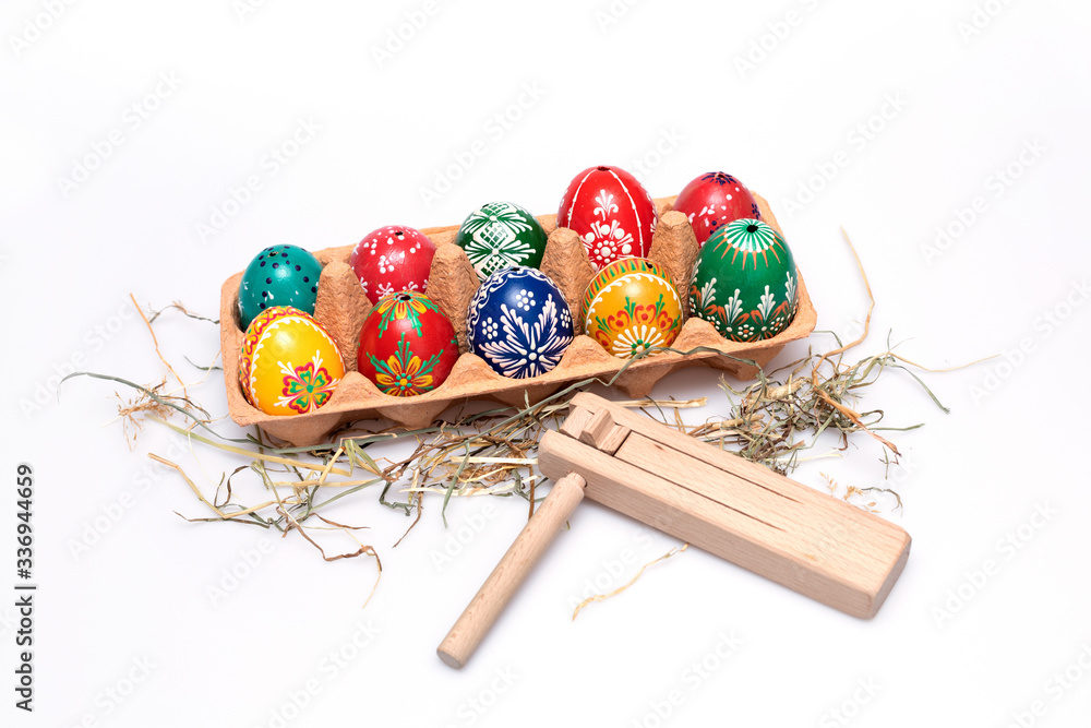 Wall mural Beautiful hand painted Czech Easter eggs and wooden rattle isolated on white background