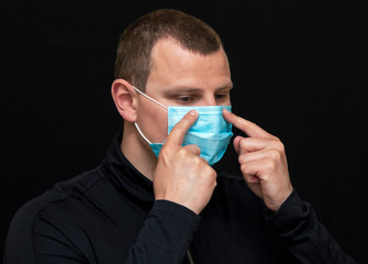 a man puts on a medical mask on his face, instructions on how to wear a mask
