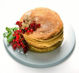 pancakes on a white plate with currant jam and berries