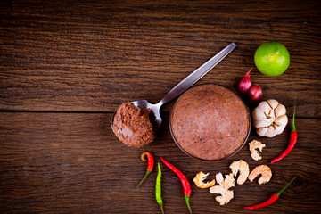 top view of  Shrimp Paste ( kapi ) and thai ingredient  in glass bowl on wooden background.
