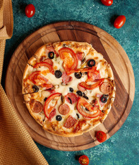 crispy pizza with tomatoes and olives and sausages