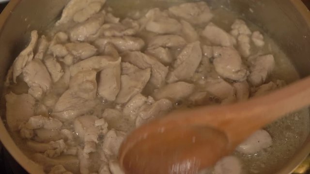 Meat beef cut into small pieces fried in a pan with smoke, close-up