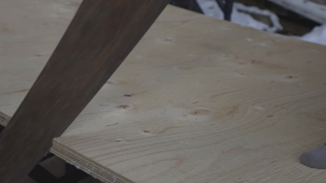 The Cutting Of Wood Plank  By Moving The Hand Saw Up And Down. -close up shot