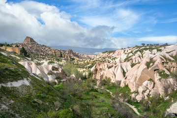 Fototapeta na wymiar Pigeon Valley Uchisar and the town is a sandstone mountain filled with houses, tunnels and windows. During the summer, daytime blue skies with beautiful clouds in Cappadocia, Turkey.