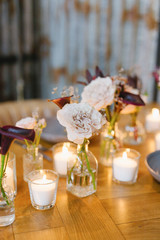 Wooden wedding table decoration with flowers and candles.