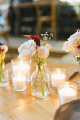 Wooden wedding table decoration with flowers and candles.