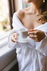 girl with a cup of coffee near the window