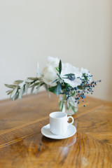 bouquet of flowers and a coffee cup on the table