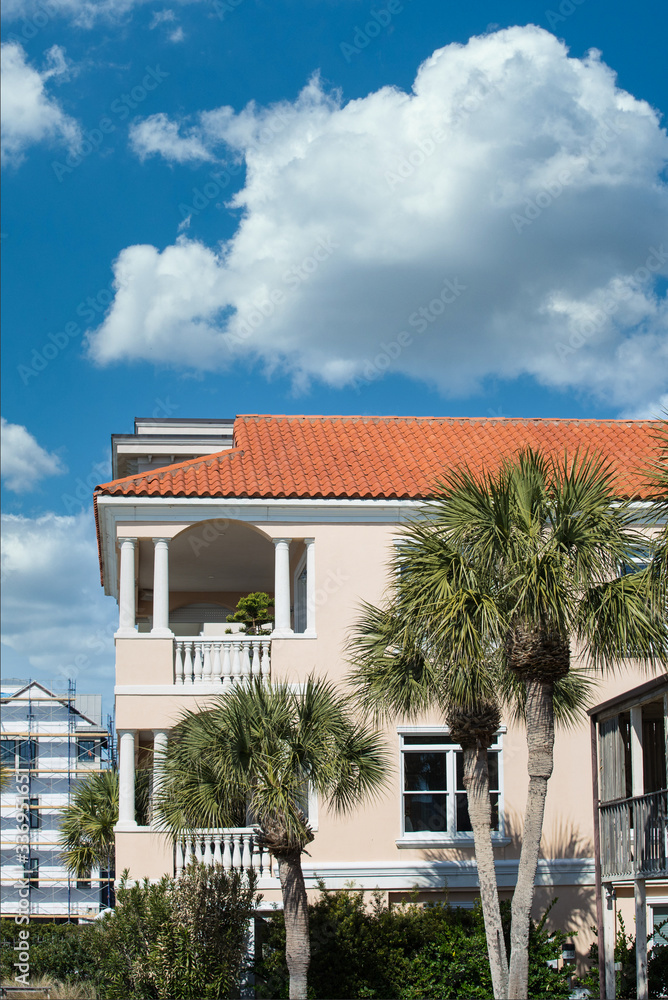 Wall mural A beautiful stucco beach resort with red tile roof under clear blue sky