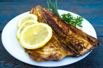 Baked mackerel fish on a white plate