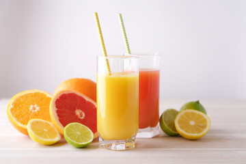 Varied citrus juice in glasses on light background. Refreshing lemonade. Breakfast beverage