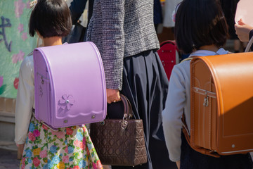 入学式に向かうランドセルをしょった新一年生と保護者の列