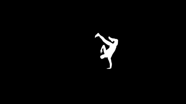 Breakdancer silhouette dancing on a stage against colorful spotlights in slow motion