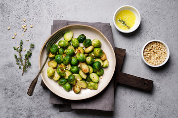 Brussels sprouts roasted with butter on gray slate background. Vegan Food Concept. Copy space, top view, flat lay