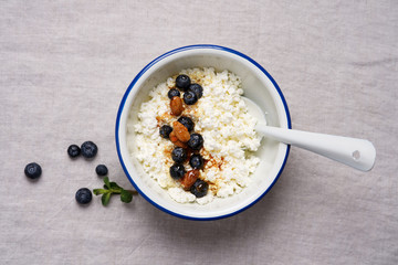 Fresh cottage cheese in bowl for breakfast. Gray tablecloth background