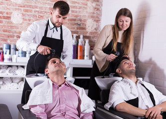 Hairdressers washing hair of clients