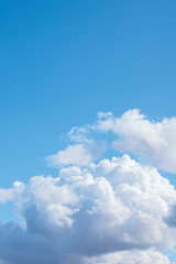 big white cumulus clouds in the blue sky as a natural background