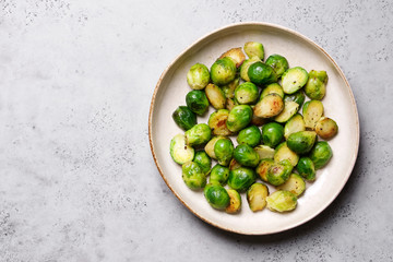 Brussels sprouts roasted with butter on gray slate background. Vegan Food Concept. Copy space, top view, flat lay