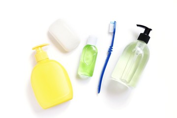 Soap packing, sanitizer gel in green bottle and toothbrush. Cosmetic products, toiletries for hygiene