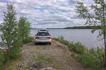 Lofoten, Norway - June 23, 2017: A gray car parked on the shore of a Norwegian fjord