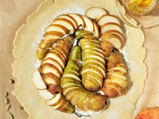 Homemade Seasonal French Pear Cookies - Galette with Ripe Pears, Cardamom and Honey. Shortbread dough for baking biscuits with pears, the process of making dessert. Top view, delicious dessert.