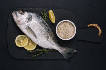 Fresh dorado fish on dark background. Top view, copy space