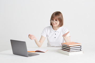 Cool happy girl goes through online training sitting at home. Remote school education on a laptop. Stay home lessons.