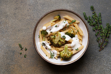 Whole grain penne pasta with broccoli and creamy sauce. Healthy lunch dish