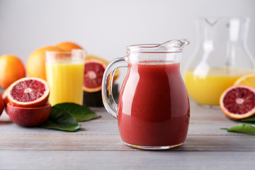 Red orange juice in glass jur. Red Sicilian and orange citrus fruits