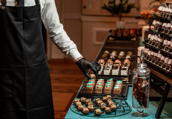 waiter adjusts a banquet table with sweets