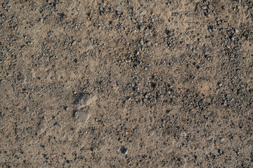 Texture of flatted dry soil as walking road with rocks