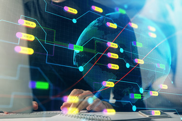 Double exposure of world map hologram with man working on computer on background. Concept of worldwideweb.