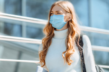 Beautiful young girl in a mask from coronovirus, student on the background of educational envy,...