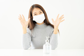 Woman wearing face mask protective for spreading of disease virus SARS-CoV-2 and hand wash cleaning by alcohol gel in office working for protection bacteria and virus, Covid-19 Coronavirus concept