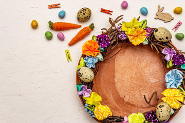 Hand crafted Easter wicker wreath with quail eggs and handmade flowers. Birch branches, polka dot satin ribbon. Stay at home concept. Festive Easter background