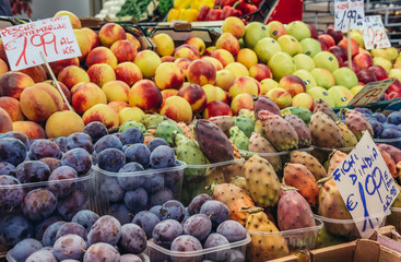 Stall with varieties of fruits on covered food market - Mercato Delle Erbe in historic part of Bologna city, Italy