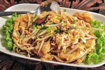 Stir fried fish maw in a white plate on a wooden table