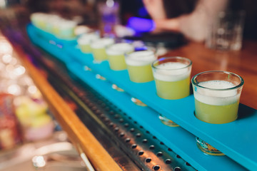 Row of shots on the counter, first is sharp and then they are blurried away.