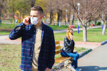 Obraz premium a guy and a girl are sitting on a bench at a distance talking to each other on the phone